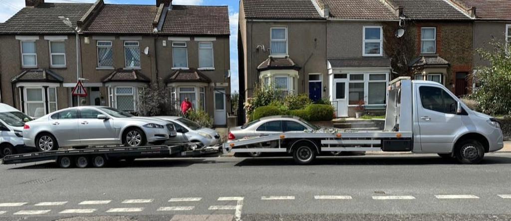 silver transporter with trailer with Jaguar XF on it